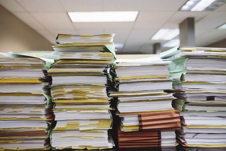 Legal documents and forms piled up Piles of documents representing how AI is Transforming Legal Documents