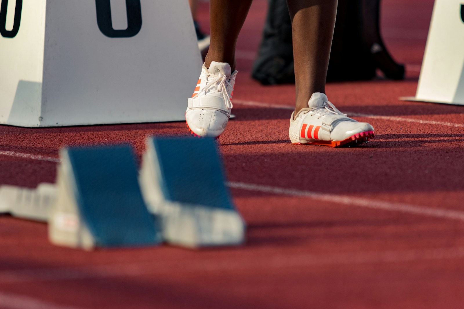 Feet of sprinter standing by starting blocks