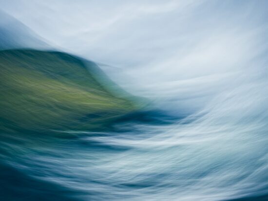 Abstract seascape created using intentional camera movement during a storm in the Faroe Islands. The blurred motion captures the sea in apparent conflict with the land, evoking raw energy, turbulence and the shifting balance between water and land.